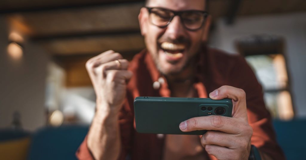 A person holding a phone and navigating to the customer support contact form within the Solitaire Smash application